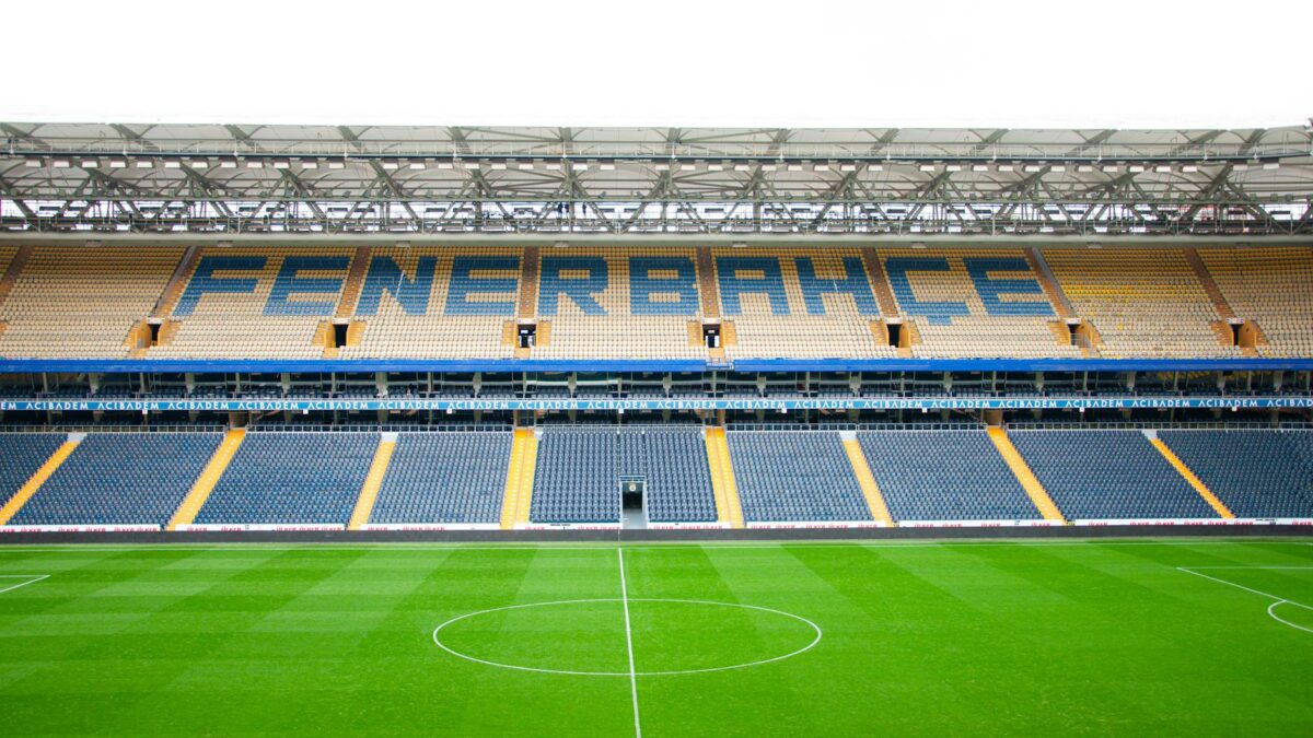 Football player at a press conference unveiling holding up a new team jersey in a packed stadium