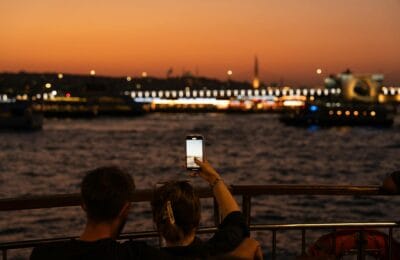 A cinematic scene from a Turkish drama series with Istanbul skyline at sunset in the background