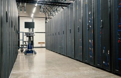 Data center server room with security monitoring screens representing tech infrastructure under threat