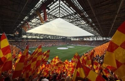 Iraqi football fans celebrating at a stadium waving national flags after World Cup qualification in 2026