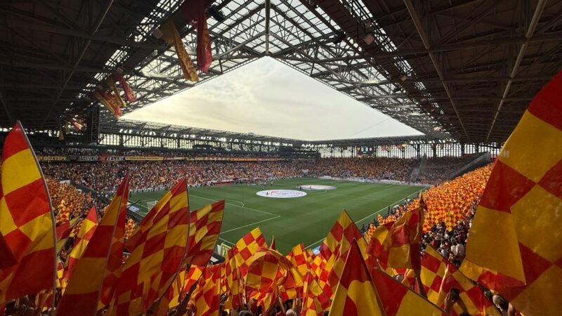 Iraqi football fans celebrating at a stadium waving national flags after World Cup qualification in 2026