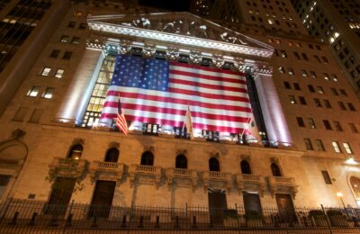 New York Stock Exchange building with American flags on Wall Street - بورصة نيويورك وول ستريت بعد وقف إطلاق النار مع إيران