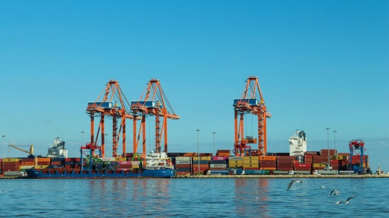 Cargo ships anchored at sea representing the humanitarian crisis of 40,000 stranded sailors during the Hormuz conflict
