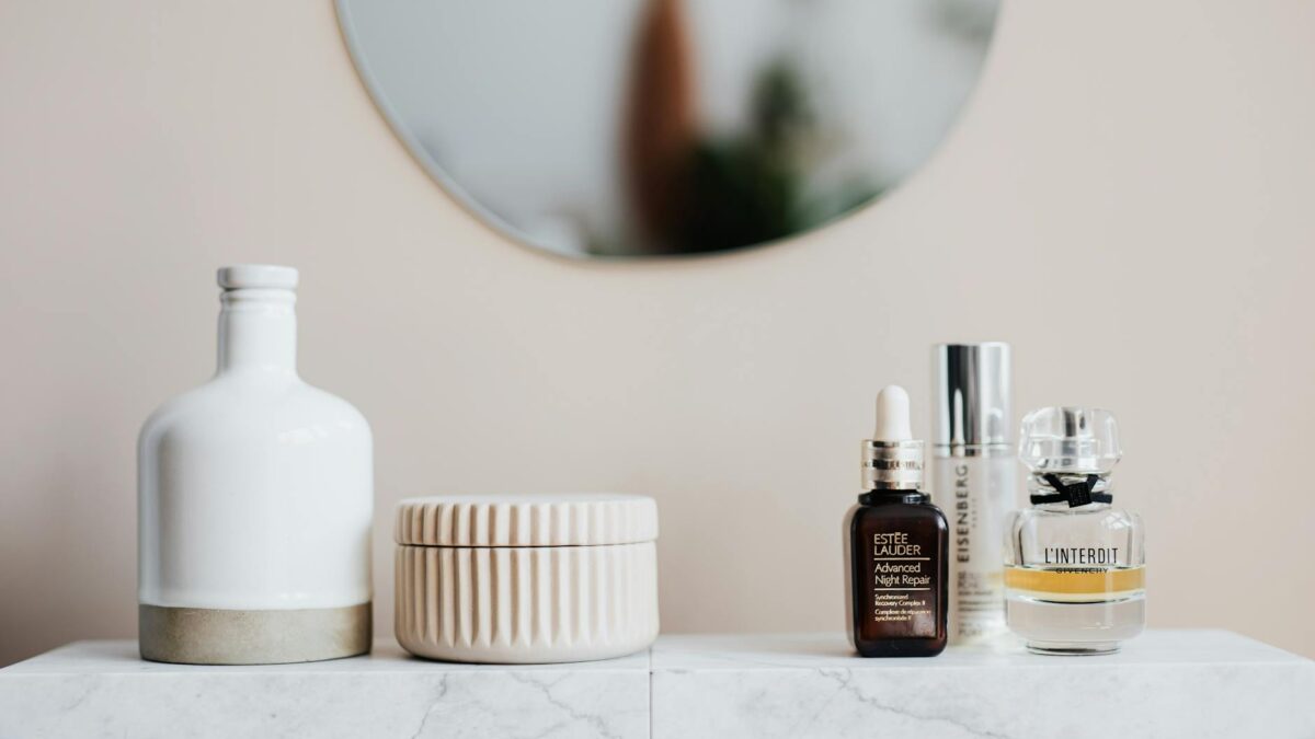 Luxury skincare bottles arranged on a marble vanity with a backlit mirror in a Middle Eastern home