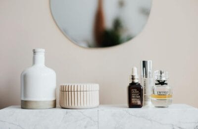 Luxury skincare bottles arranged on a marble vanity with a backlit mirror in a Middle Eastern home