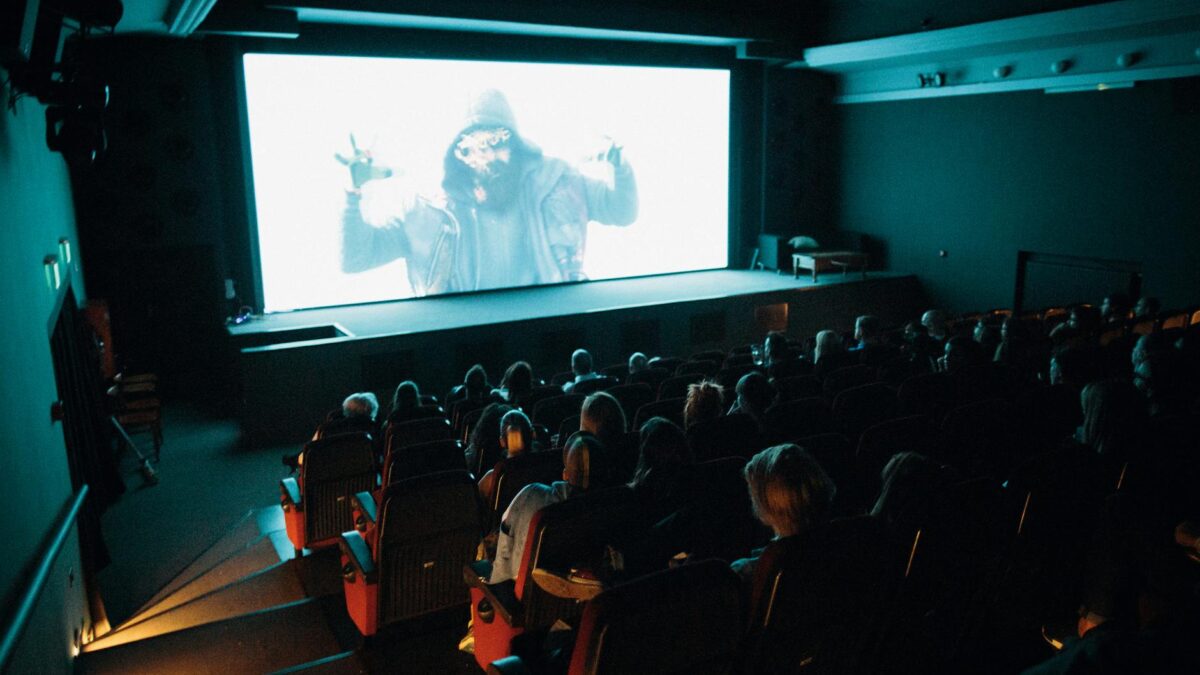 Audience members in a Middle Eastern cinema watching an Arabic film premiere