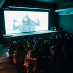 Audience members in a Middle Eastern cinema watching an Arabic film premiere