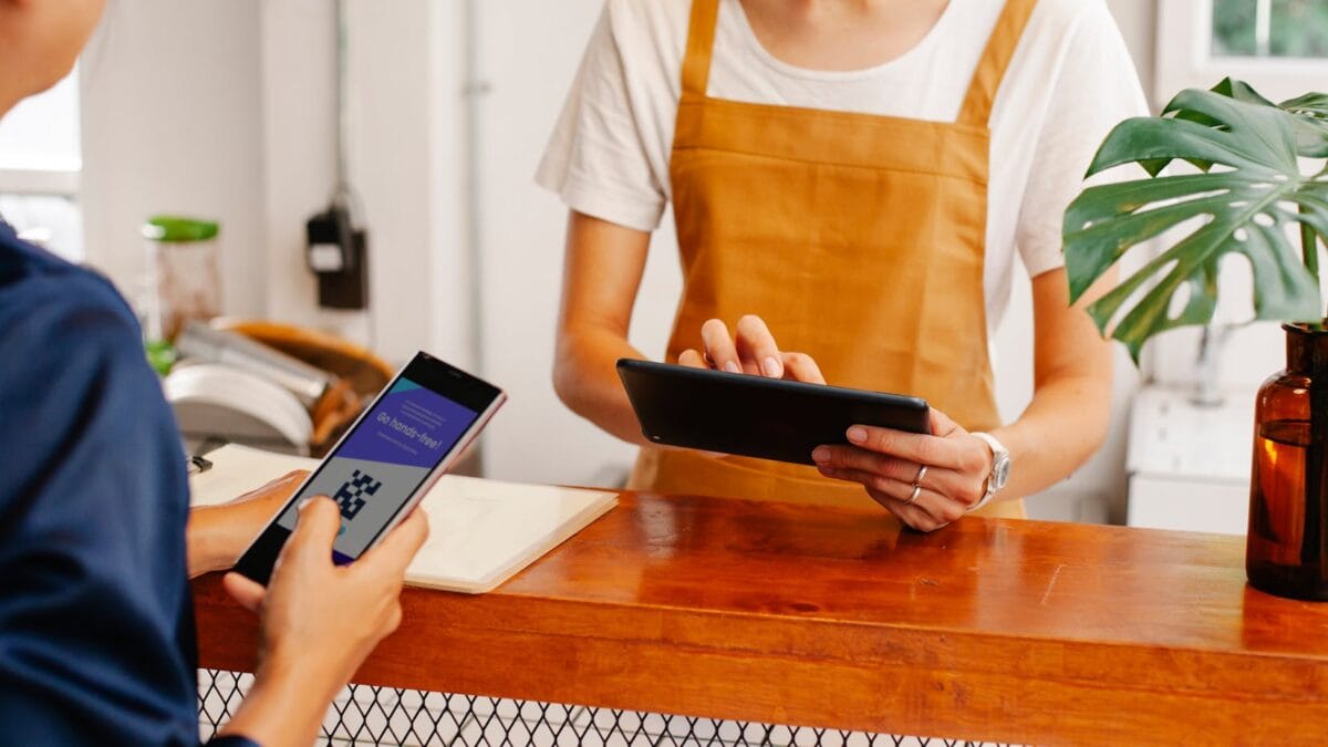 Customer scanning a QR code with a mobile fintech app at a Cairo coffee shop in 2026
