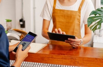Customer scanning a QR code with a mobile fintech app at a Cairo coffee shop in 2026