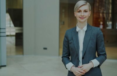 Senior professionals in business attire reviewing strategic documents at a modern Gulf-city office tower with skyline view through floor-to-ceiling windows