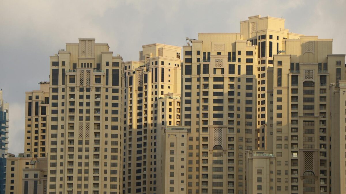 Dubai Marina skyline at sunset with luxury apartment towers and visible 'for sale' signage marking the May 2026 buyer's market shift