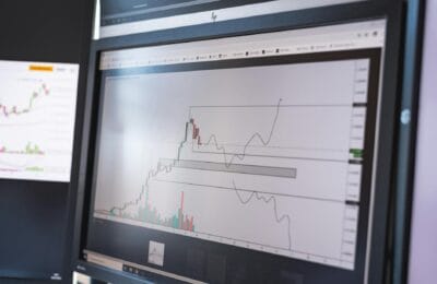 Cairo trading floor with green stock screens and the Nile skyline in the background