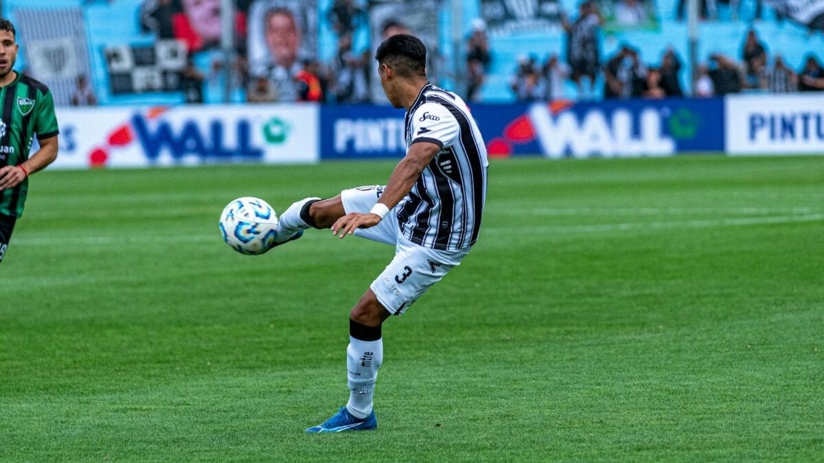 Professional footballer striking the ball during a packed stadium fixture, representing the sport that dominates the 2026 list of highest-paid Arab athletes.