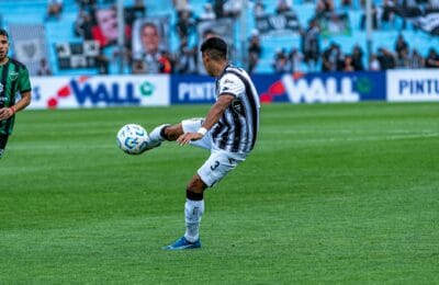 Professional footballer striking the ball during a packed stadium fixture, representing the sport that dominates the 2026 list of highest-paid Arab athletes.