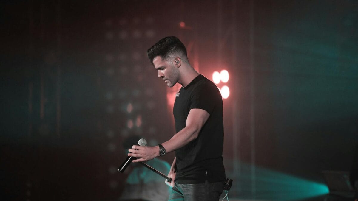 Egyptian male superstar performing on a brightly lit concert stage with smoke and lights