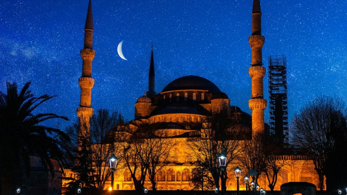 Crescent moon rising above a mosque silhouette announcing the start of Ramadan 2027