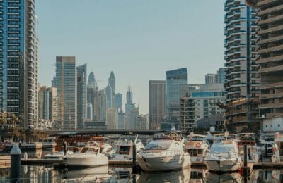Luxury yachts moored at Dubai Marina at sunset, with skyscrapers in the background, symbolizing the city's extreme concentration of wealth in 2026.