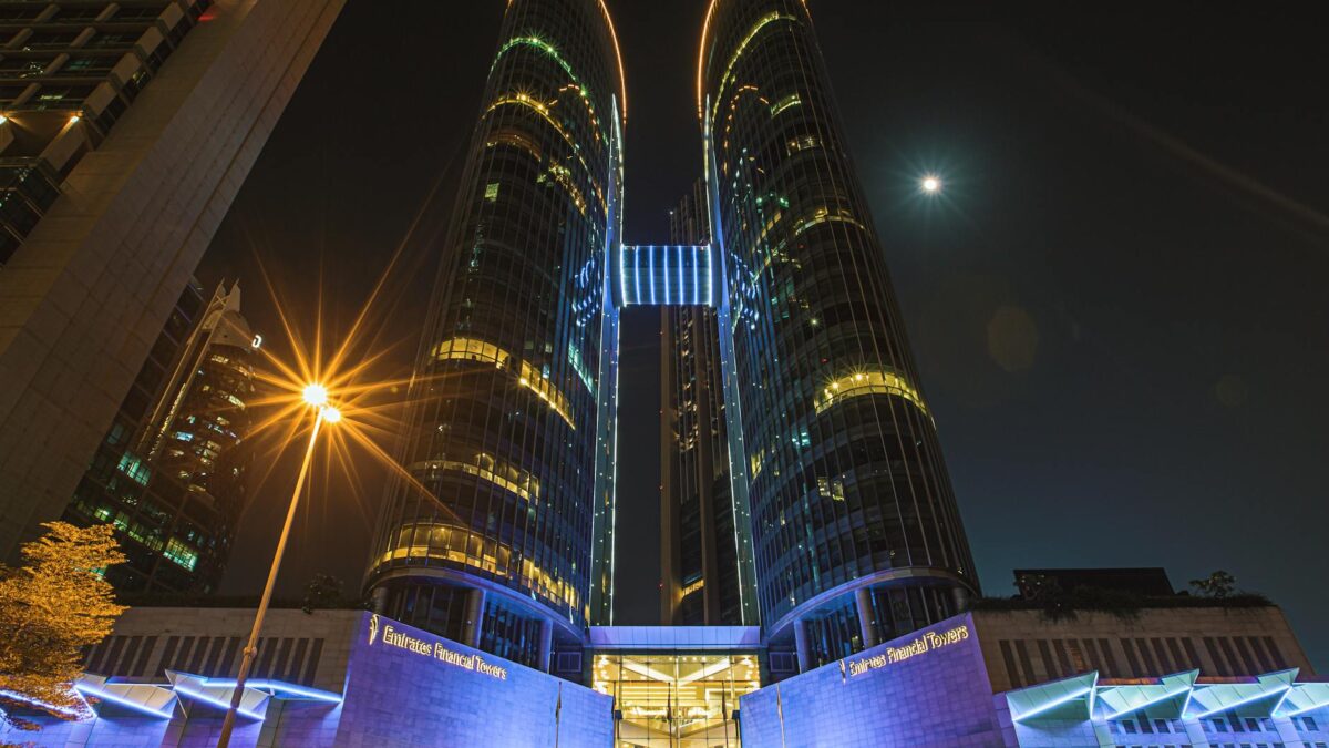 Illuminated Dubai financial district banking towers at night with DIFC skyline