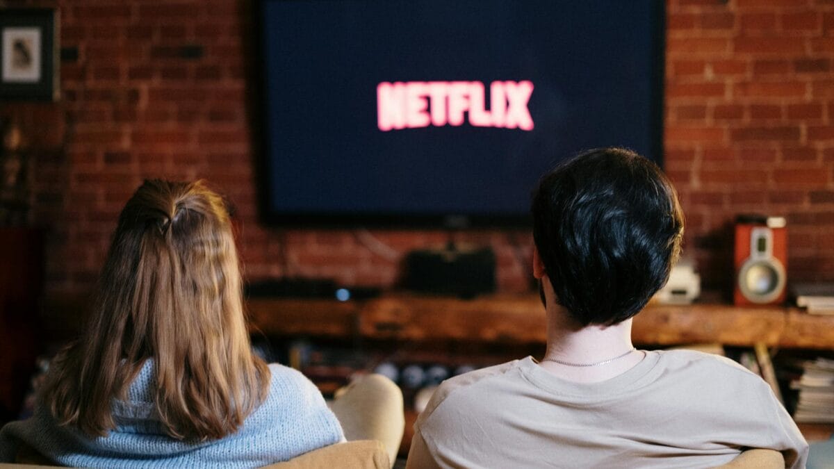 A modern living room with a smart television displaying multiple streaming service options on a cozy evening