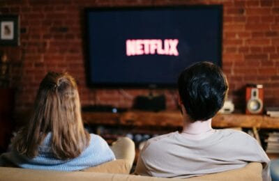 A modern living room with a smart television displaying multiple streaming service options on a cozy evening